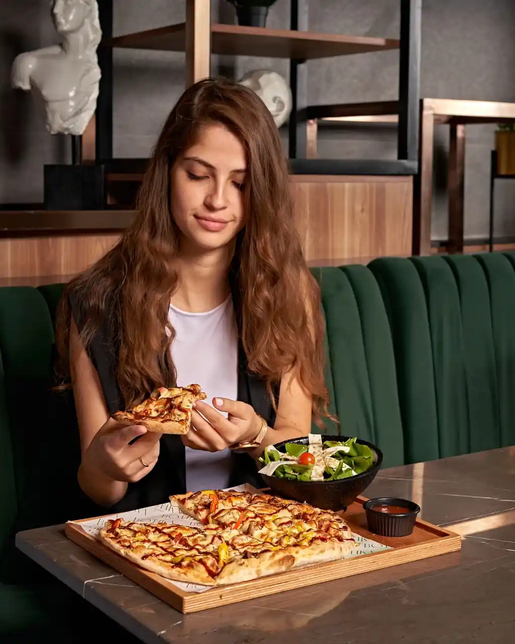 Iloinen seurue nauttimassa pizzaa Purellavorian tyylikkäässä ympäristössä